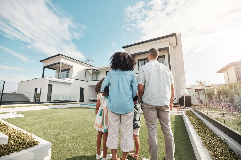 Family standing in front of their new home